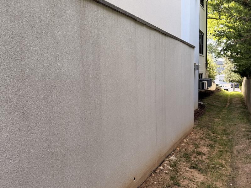 After: the same stucco wall with the rust streak removed